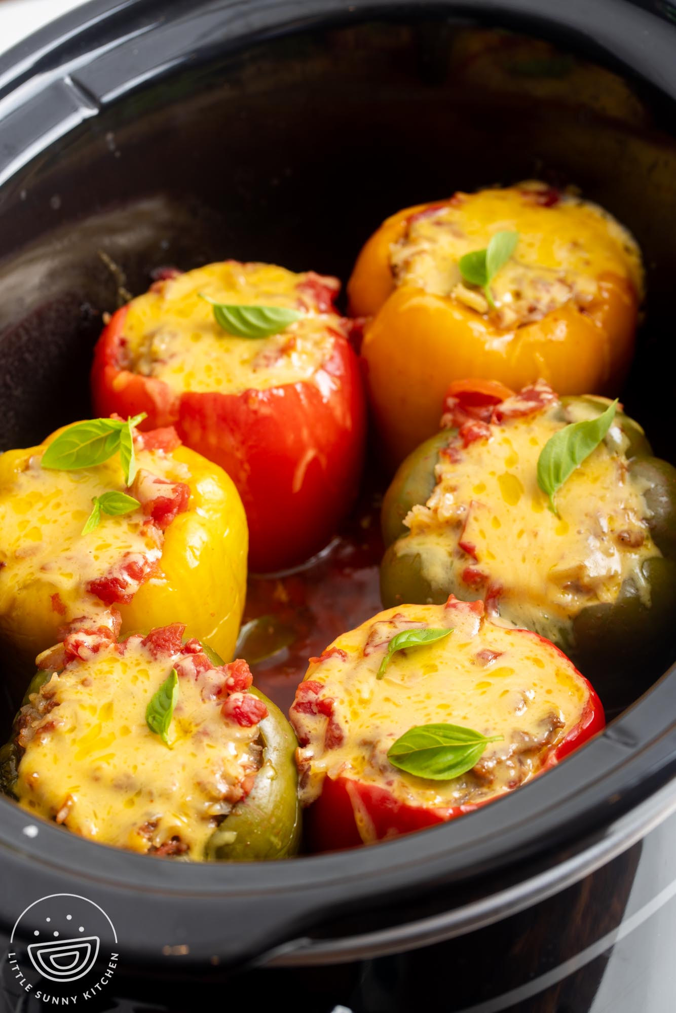 stuffed peppers in a slow cooker topped with melted cheese.