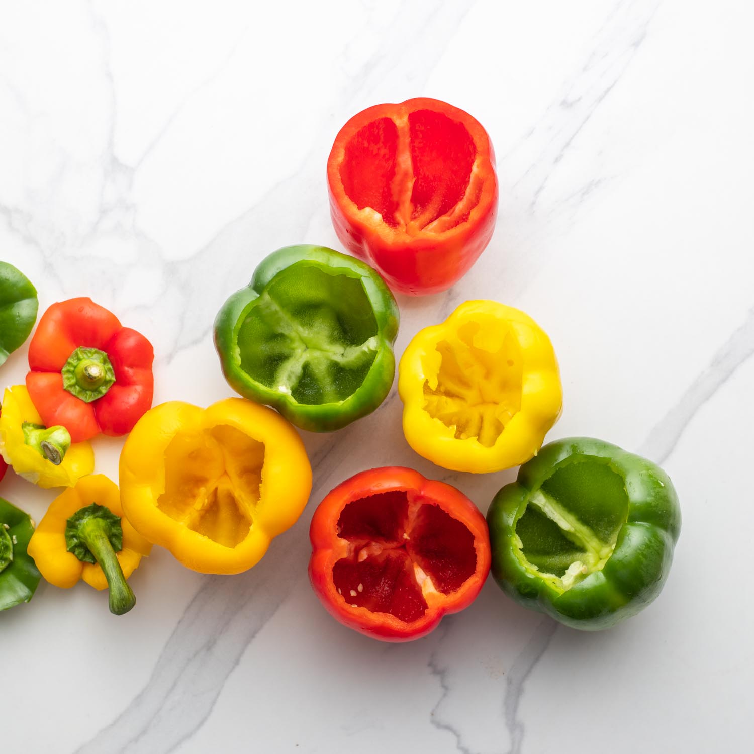 Multicolored bell peppers with their tops and seeds removed.