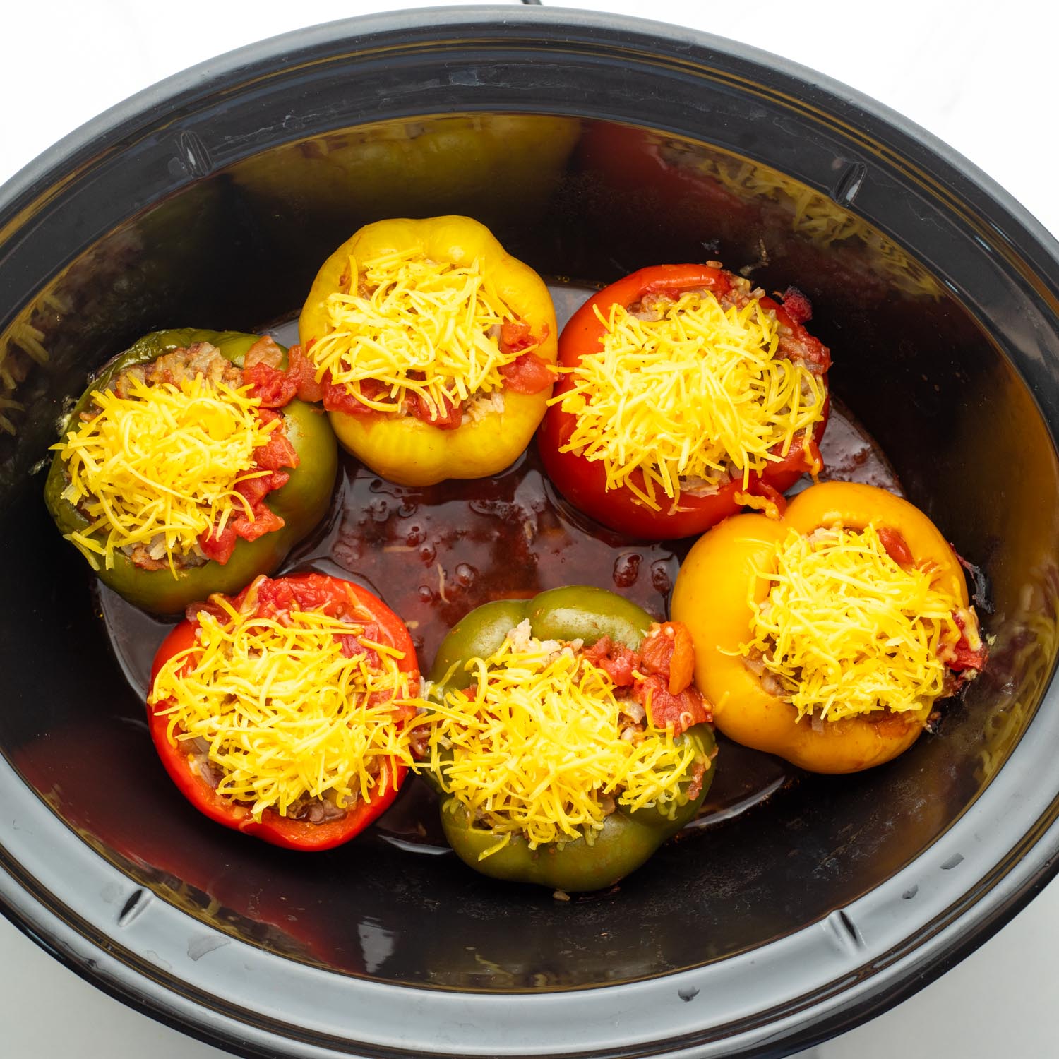 Slow cooked stuffed peppers topped with shredded cheese.