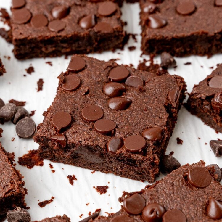 sweet potato brownies with chocolate chips cut into squares and spread out on a piece of parchment paper.