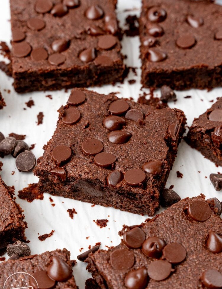 sweet potato brownies with chocolate chips cut into squares and spread out on a piece of parchment paper.