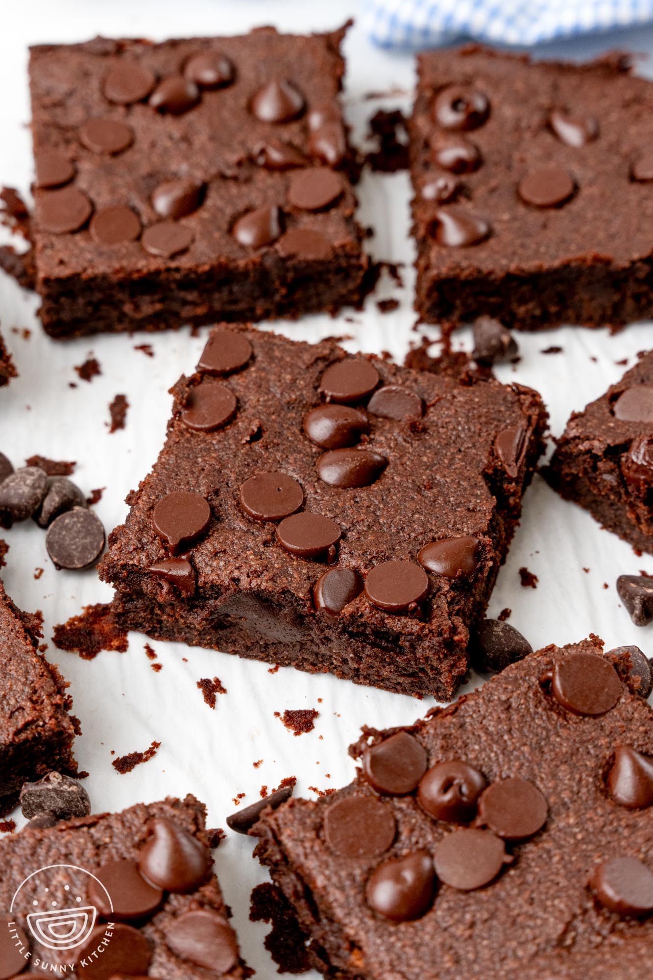 sweet potato brownies with chocolate chips cut into squares and spread out on a piece of parchment paper.