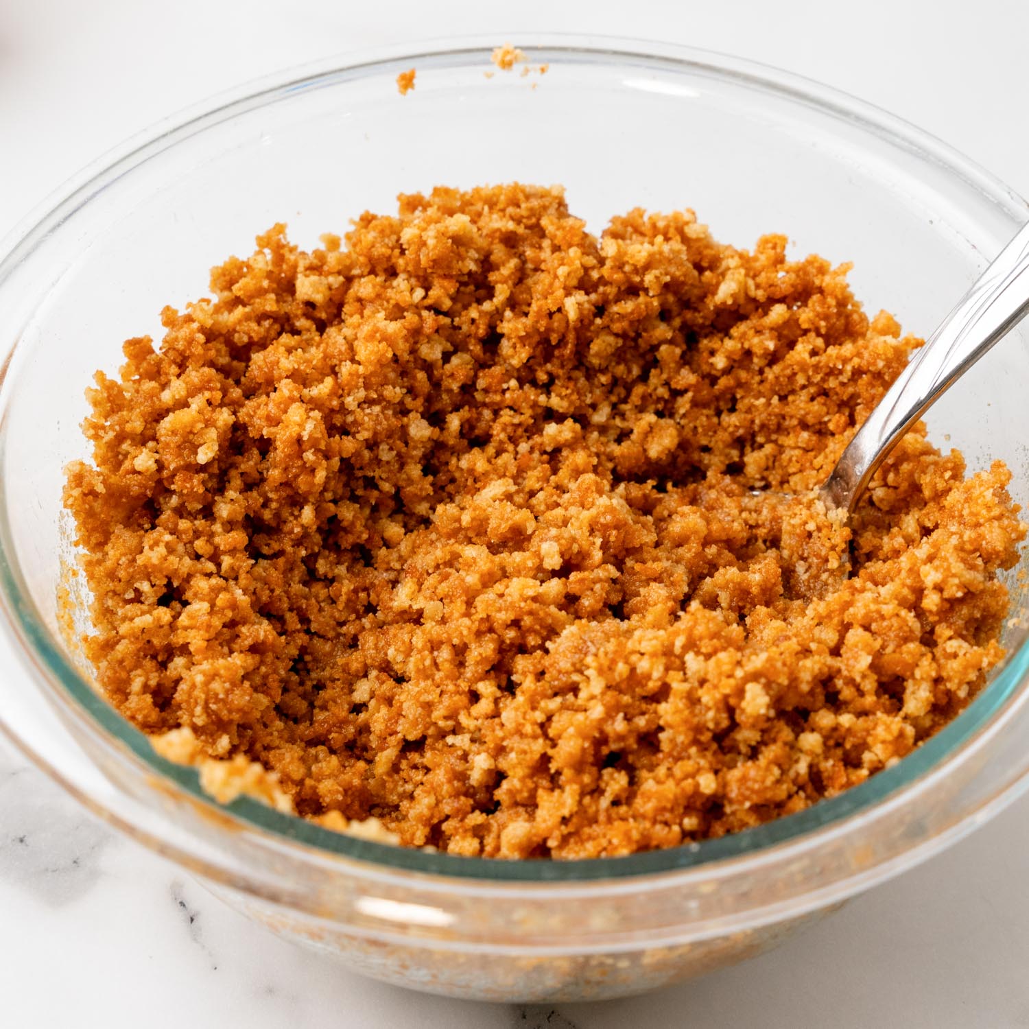 a small glass bowl of gingersnap cookie crumbs mixed with sugar and melted butter.