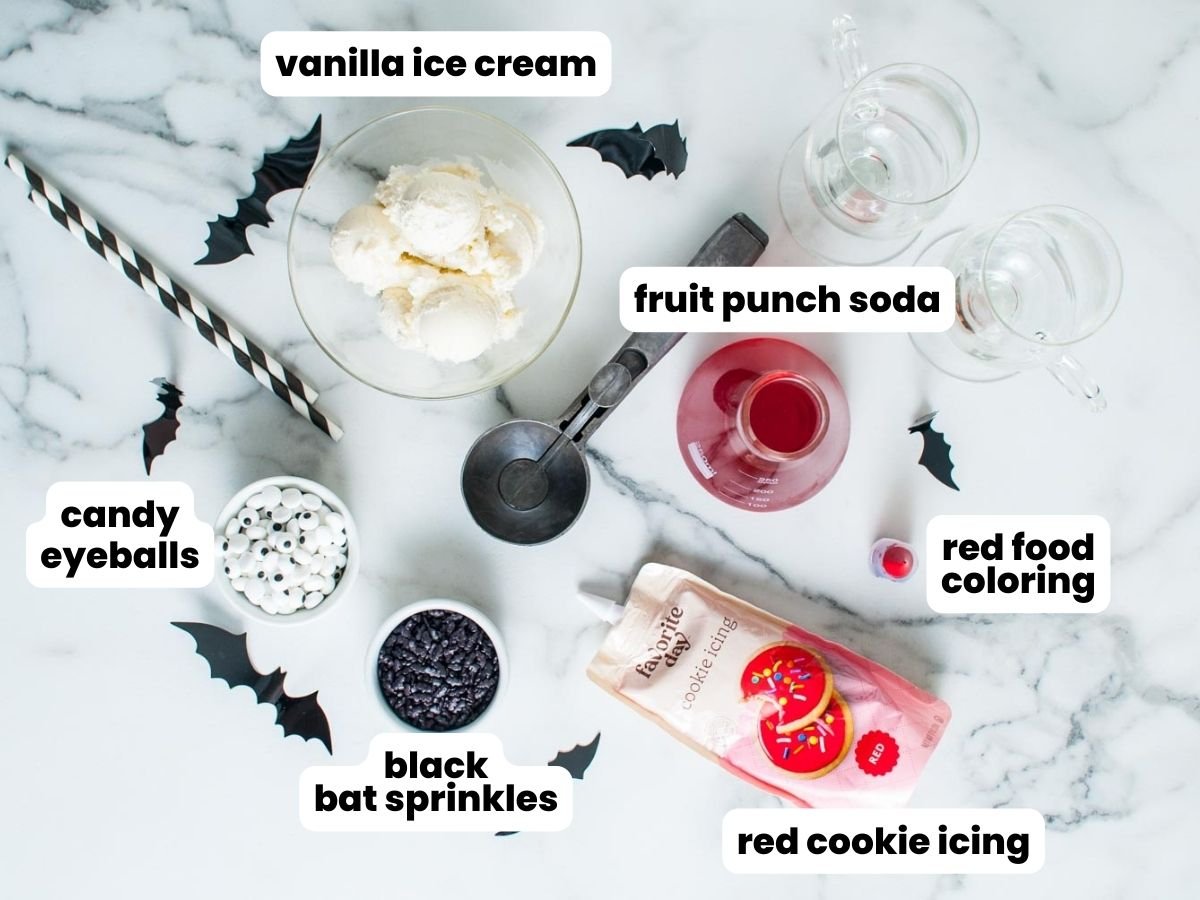 The ingredients needed to make spooky vampire ice cream floats, including candy eyeballs, black sprinkles, red food coloring, and red cookie icing.