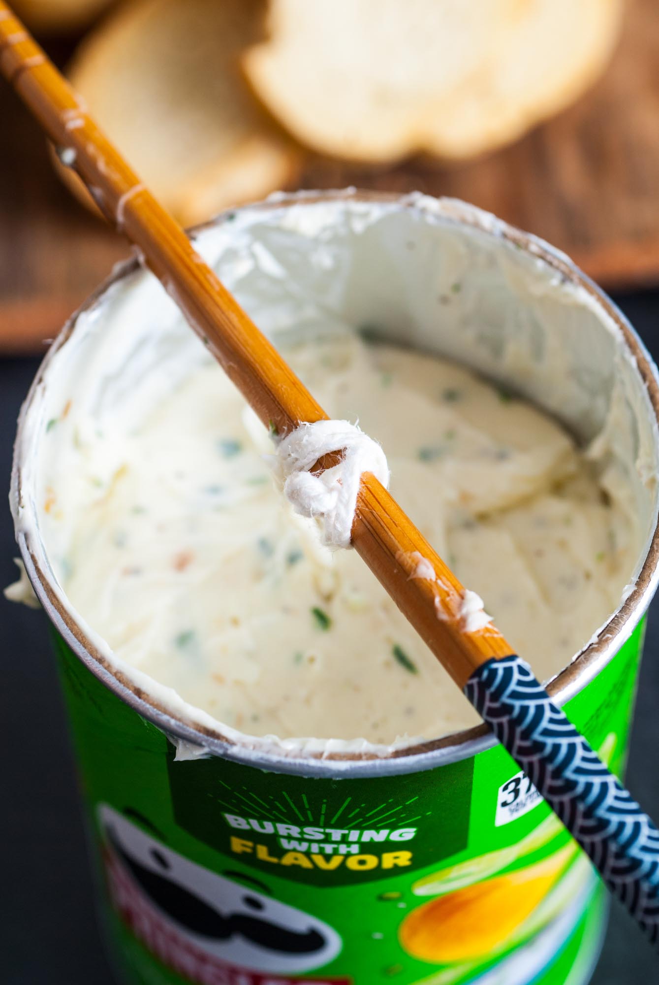 a chopstick holding a foodsafe candle wick over a butter candle that is molded in a pringles can.