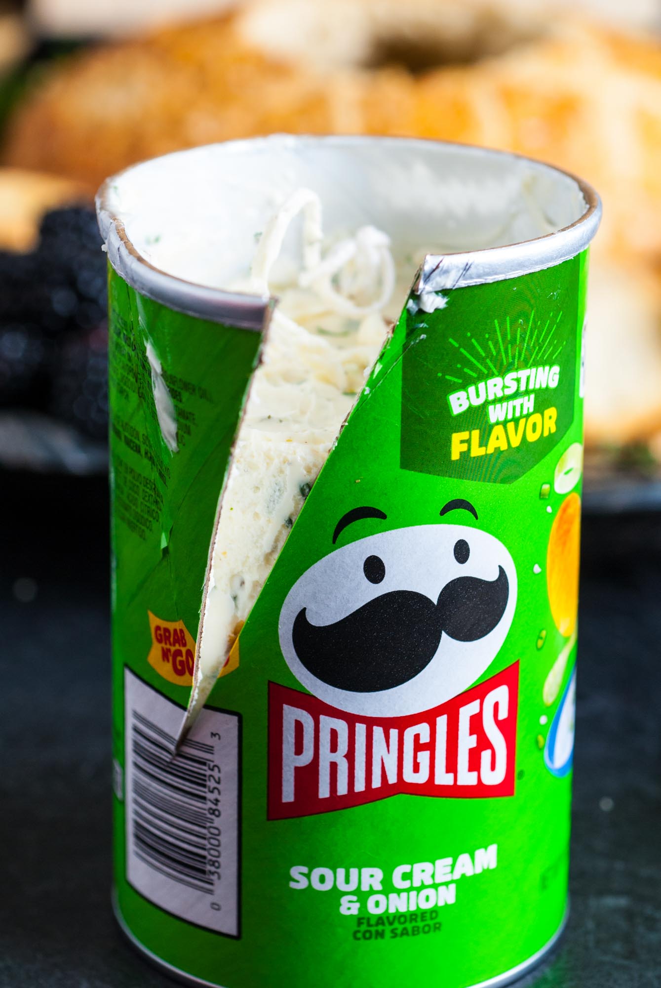 a pringles sour cream and onion can, grab and go size, filled with garlic herb butter. The can is cut down the side to open it.