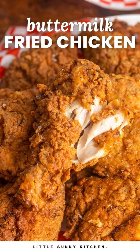 Crispy fried chicken drumstick showing the white meat on the inside to show doneness, and overlay text that says "buttermilk fried chicken"