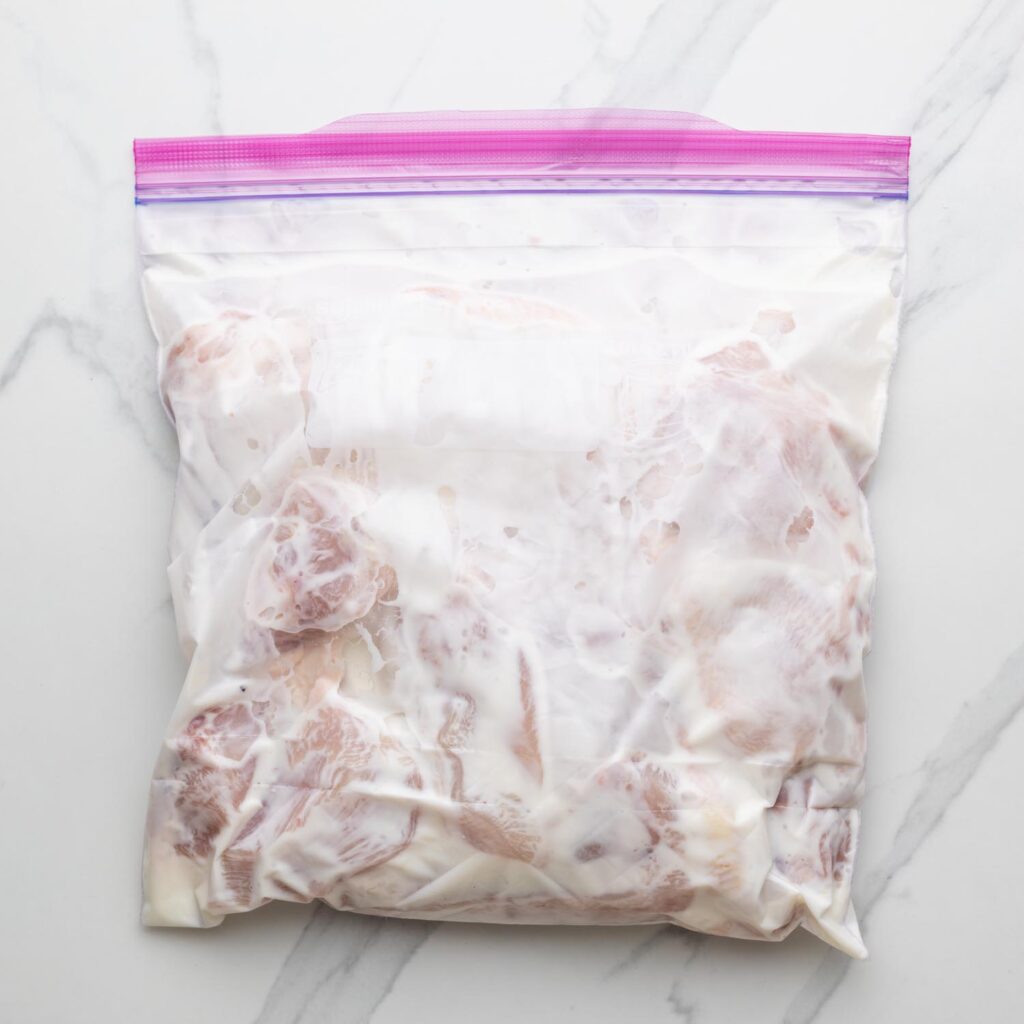 Chicken being marinated in a ziptop bag