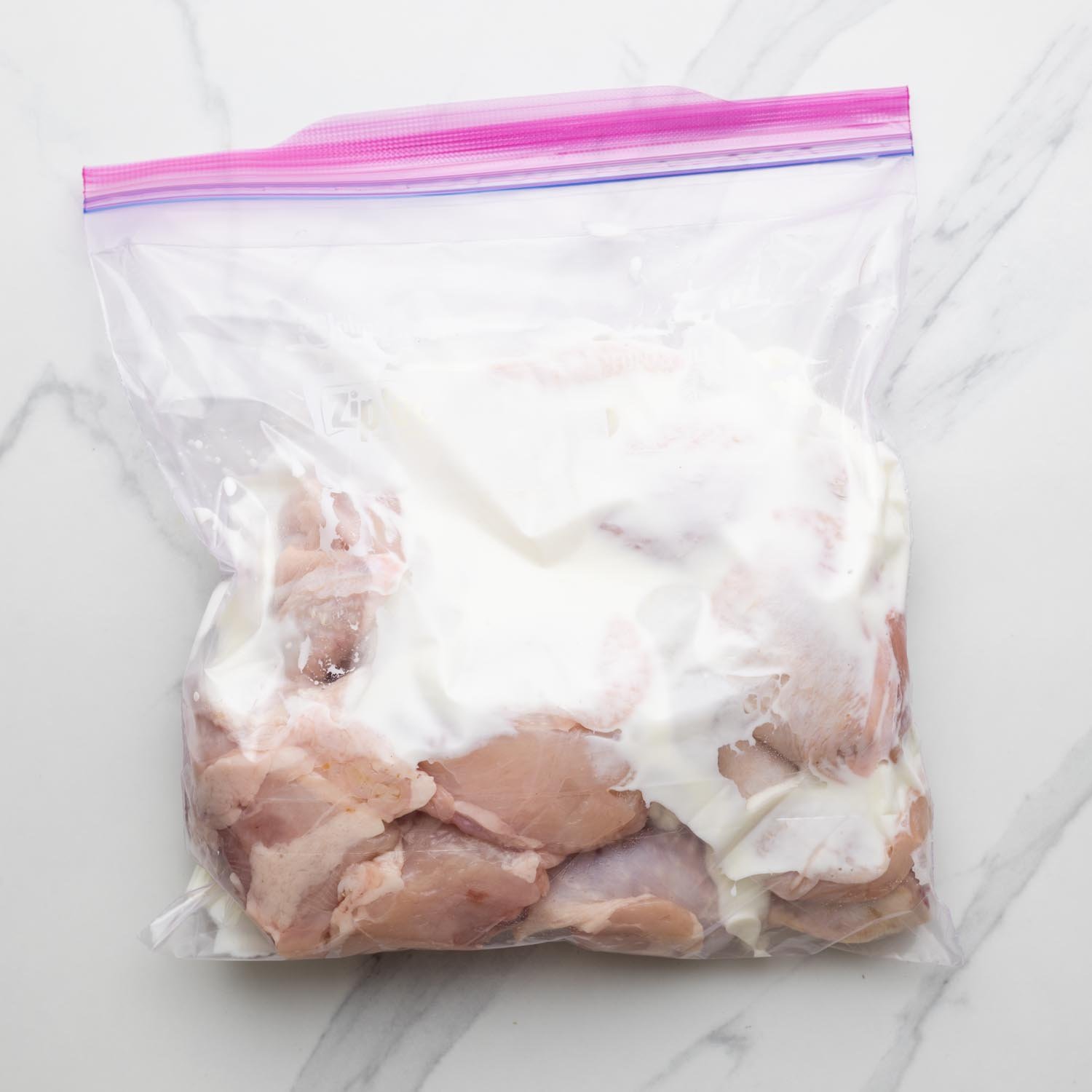 Chicken being marinated in a ziptop bag