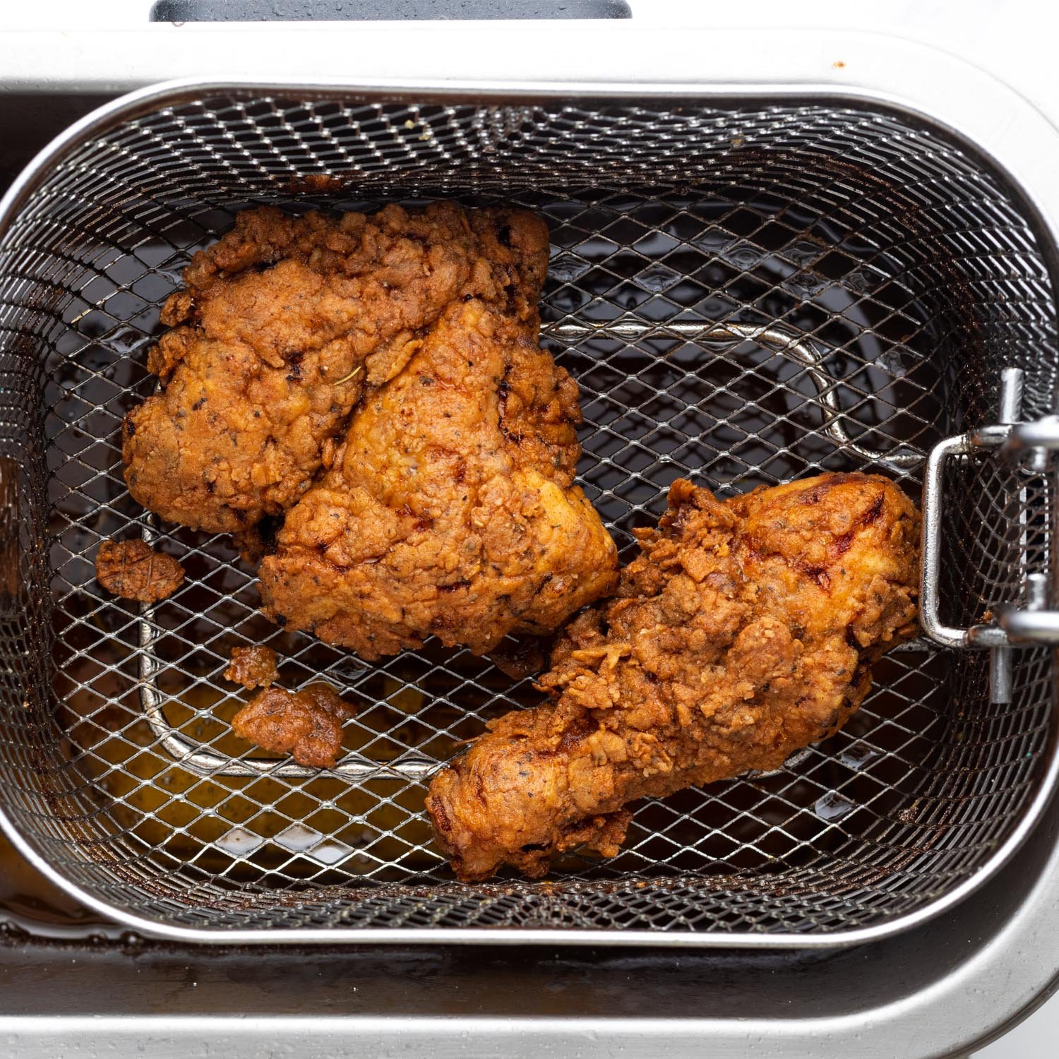 Fried chicken in a basket in a fryer