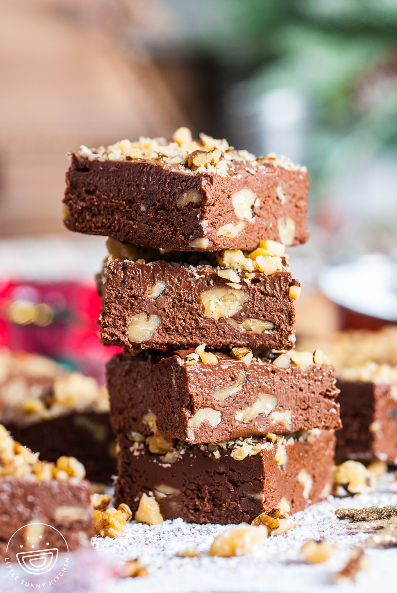 four pieces of fantasy fudge with walnuts stacked on top of each other to show the creamy texture.