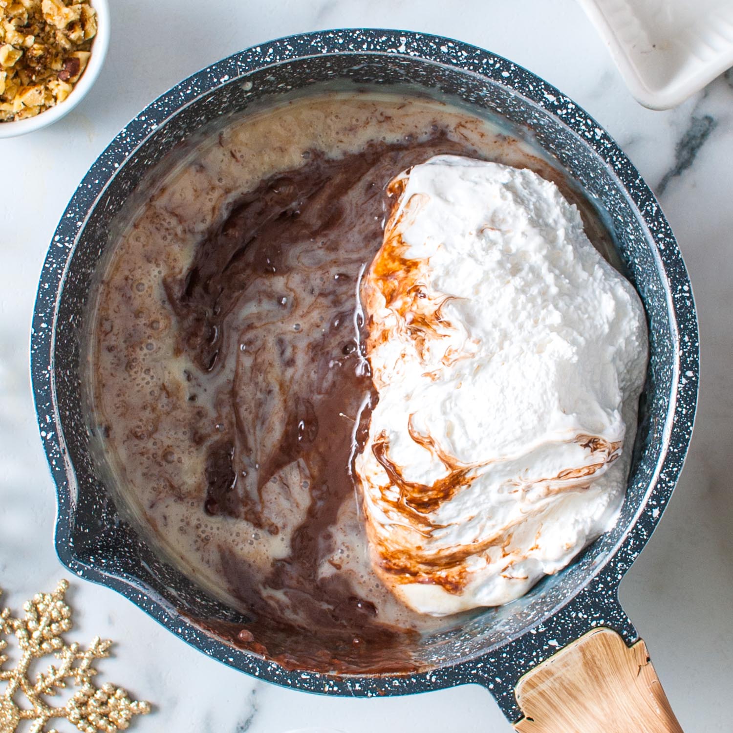 Marshmallow creme added to a pot of fudge and melting.