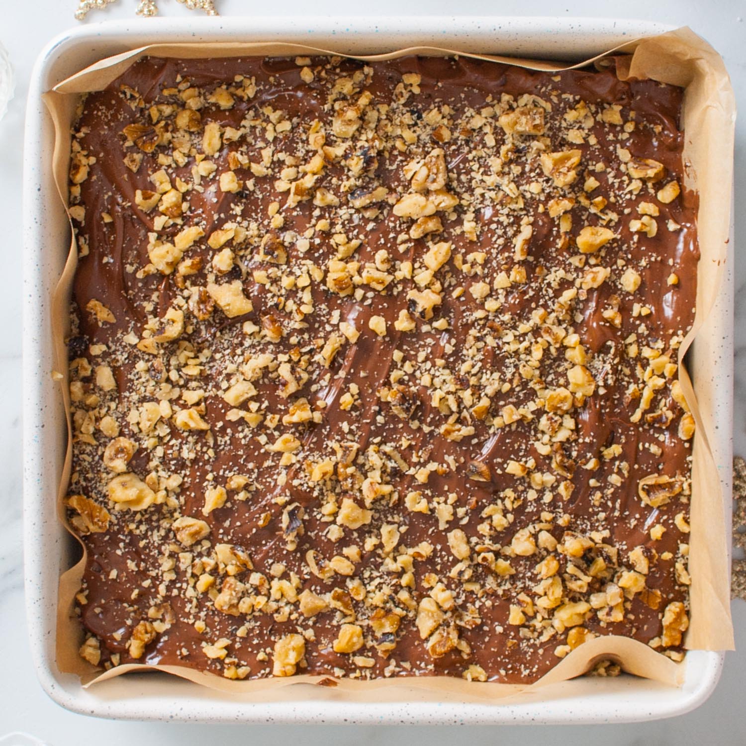 a square pan of fantasy fudge topped with chopped walnuts.