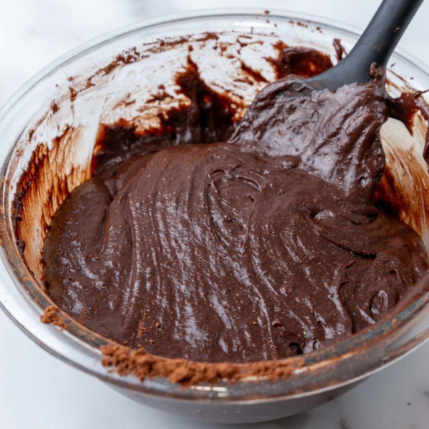 brownie batter mixed in a bowl with a spatula.