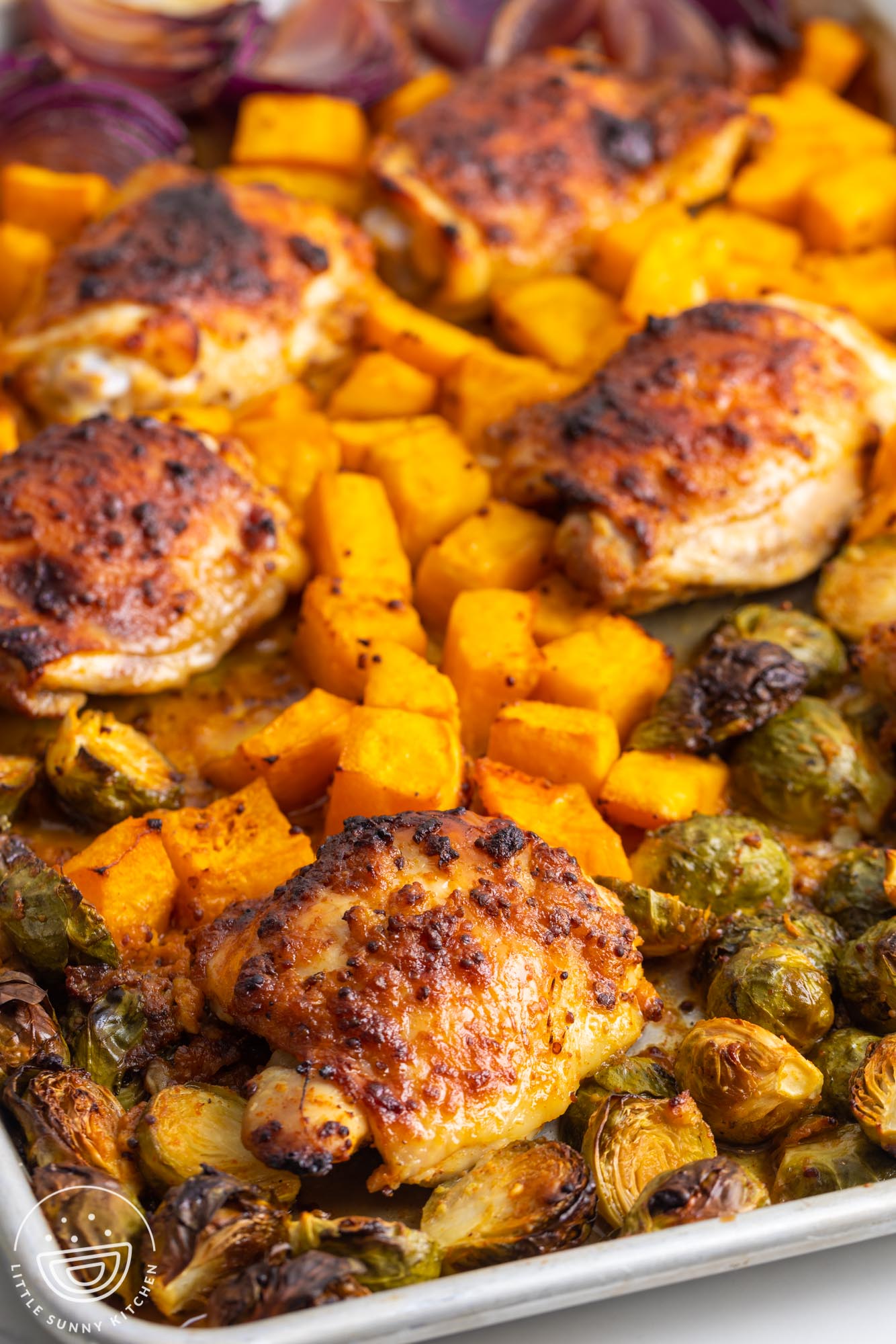 honey mustard chicken and fall veggies baked on a sheet pan.