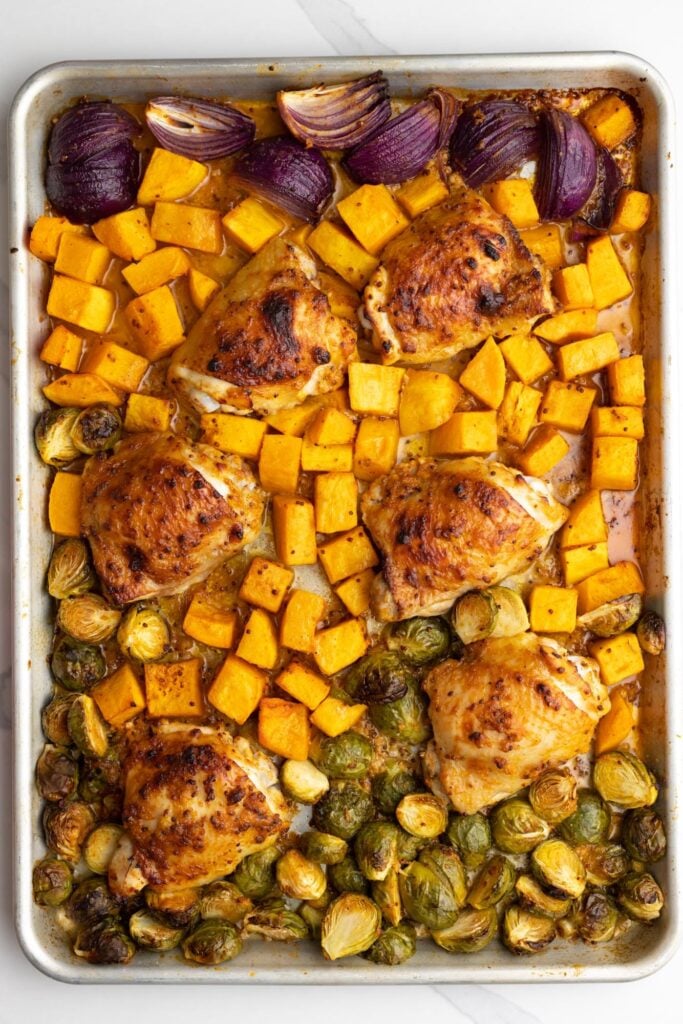 baked sheet pan chicken thighs with brussel sprouts and diced squash.