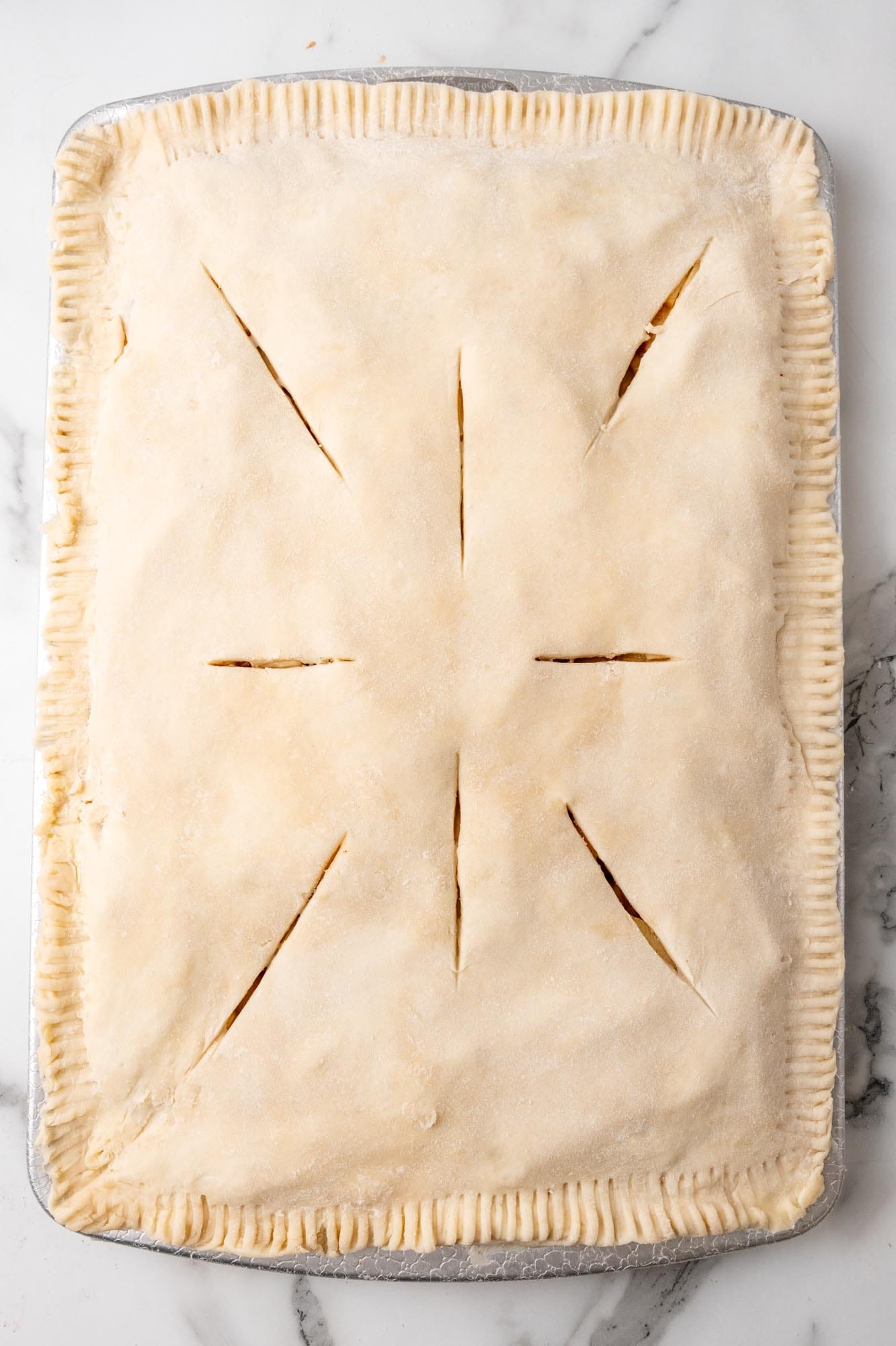 assembled rectangular apple pie with slits cut into the top crust.