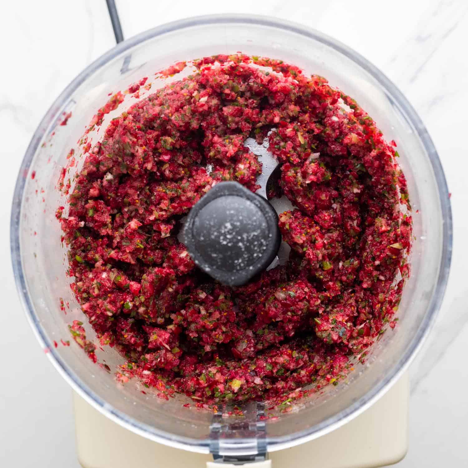 well chopped cranberry salsa in the bowl of a food processor.