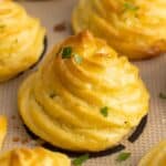 brown swirled duchess potatoes baked on a silpat mat.