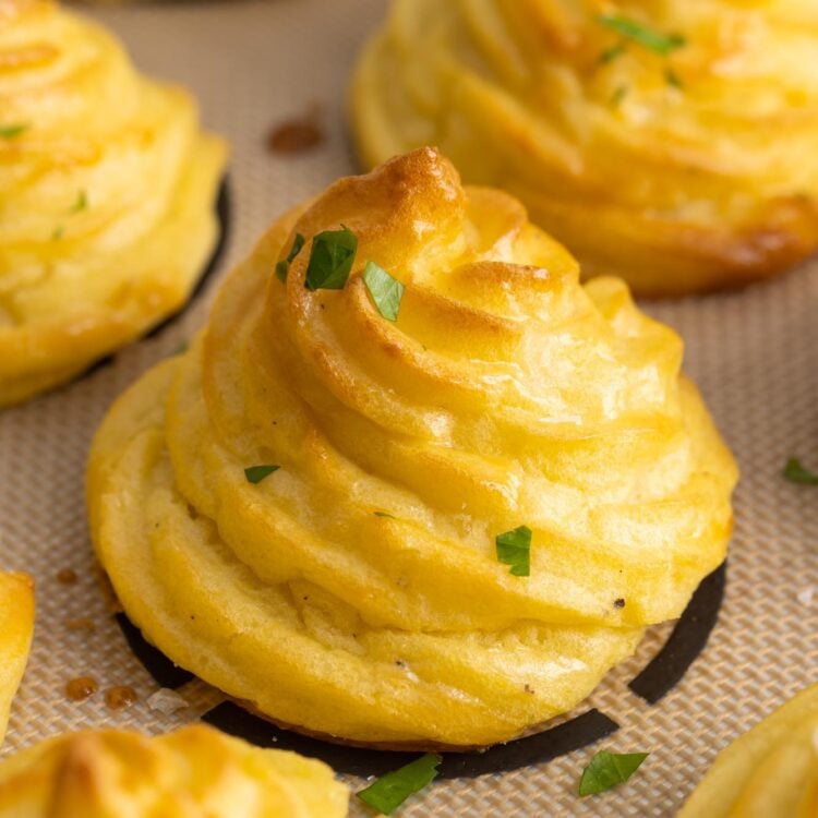 brown swirled duchess potatoes baked on a silpat mat.