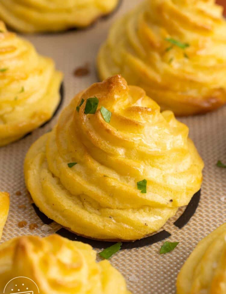 brown swirled duchess potatoes baked on a silpat mat.