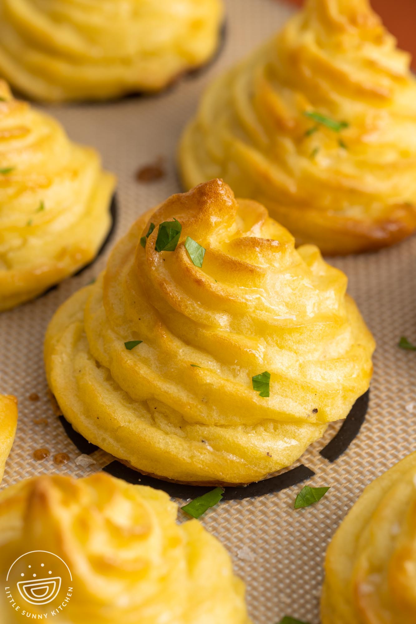 brown swirled duchess potatoes baked on a silpat mat. 