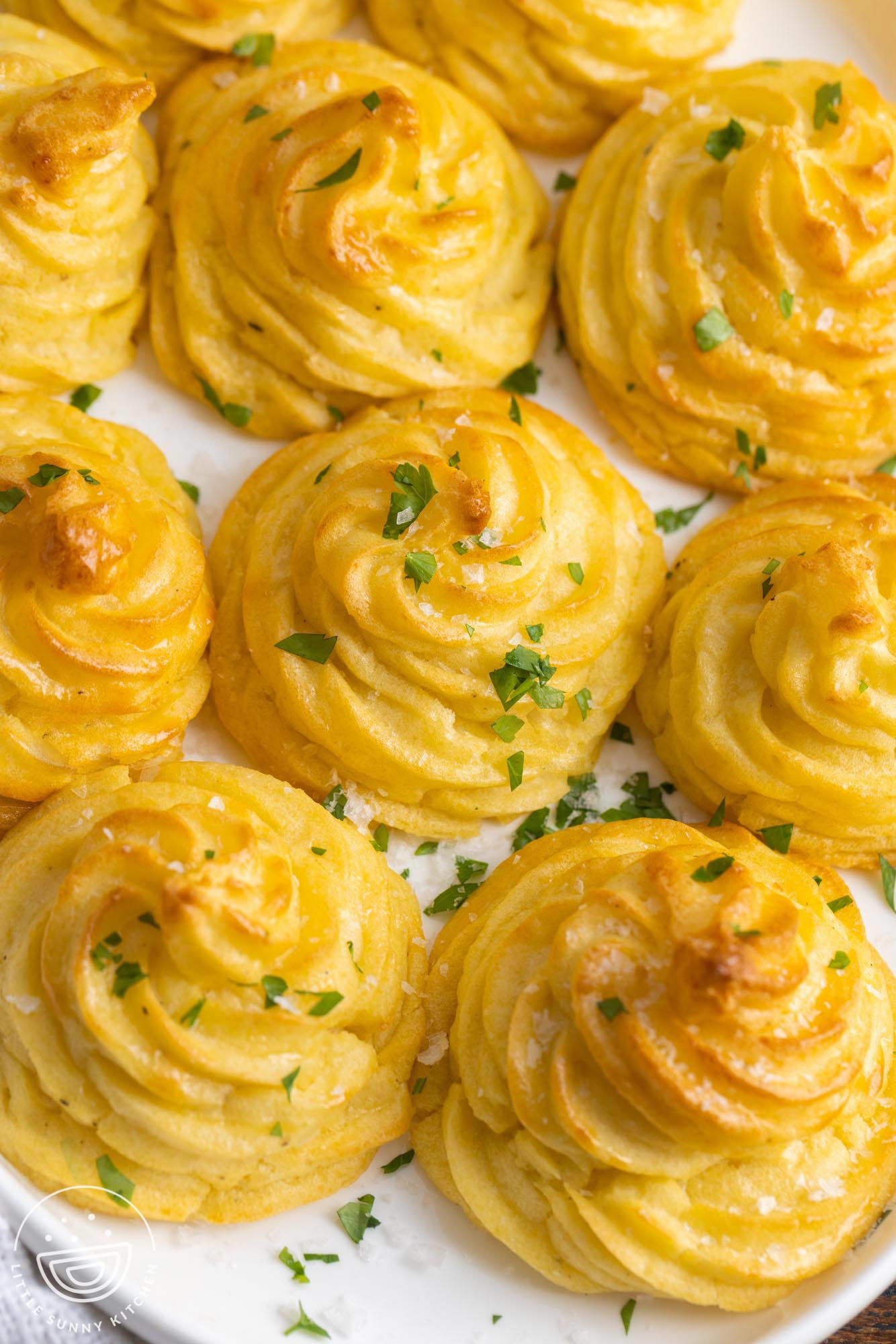 swirled duchess potatoes garnished with flaky salt and chopped parsley. 