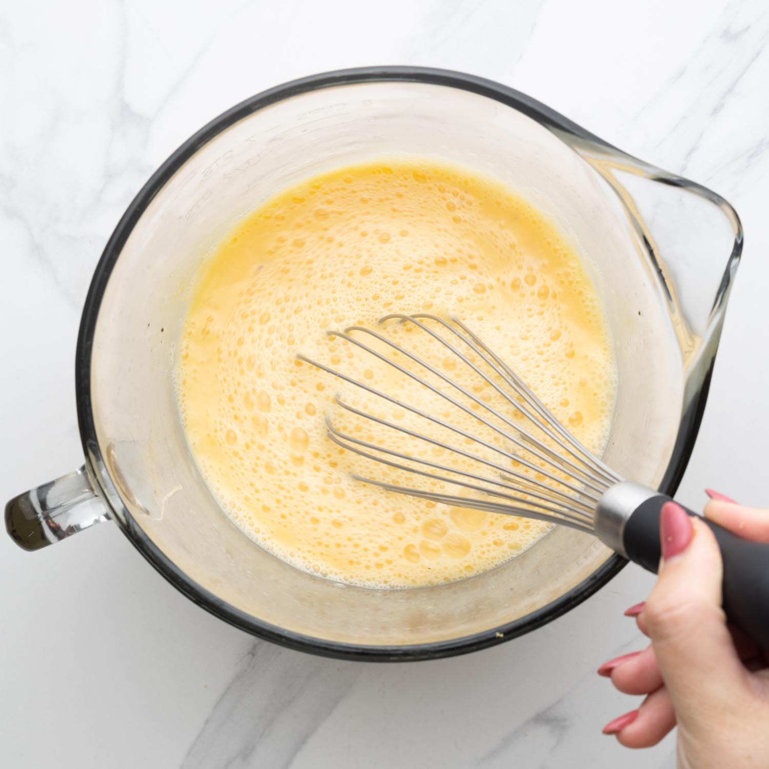 eggs whisked in a glass bowl by hand.