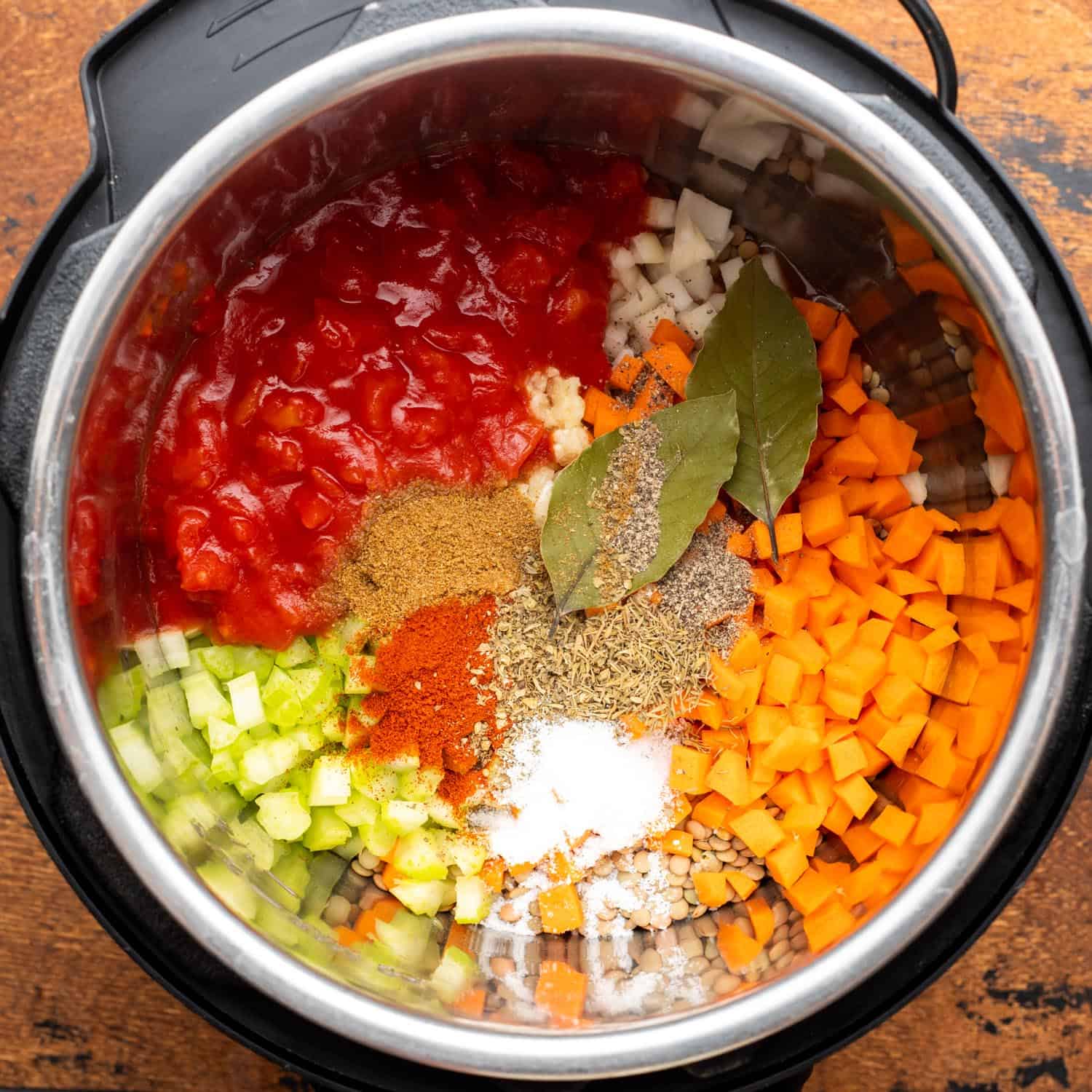 Ingredients for lentil soup layered into an Instant pot.