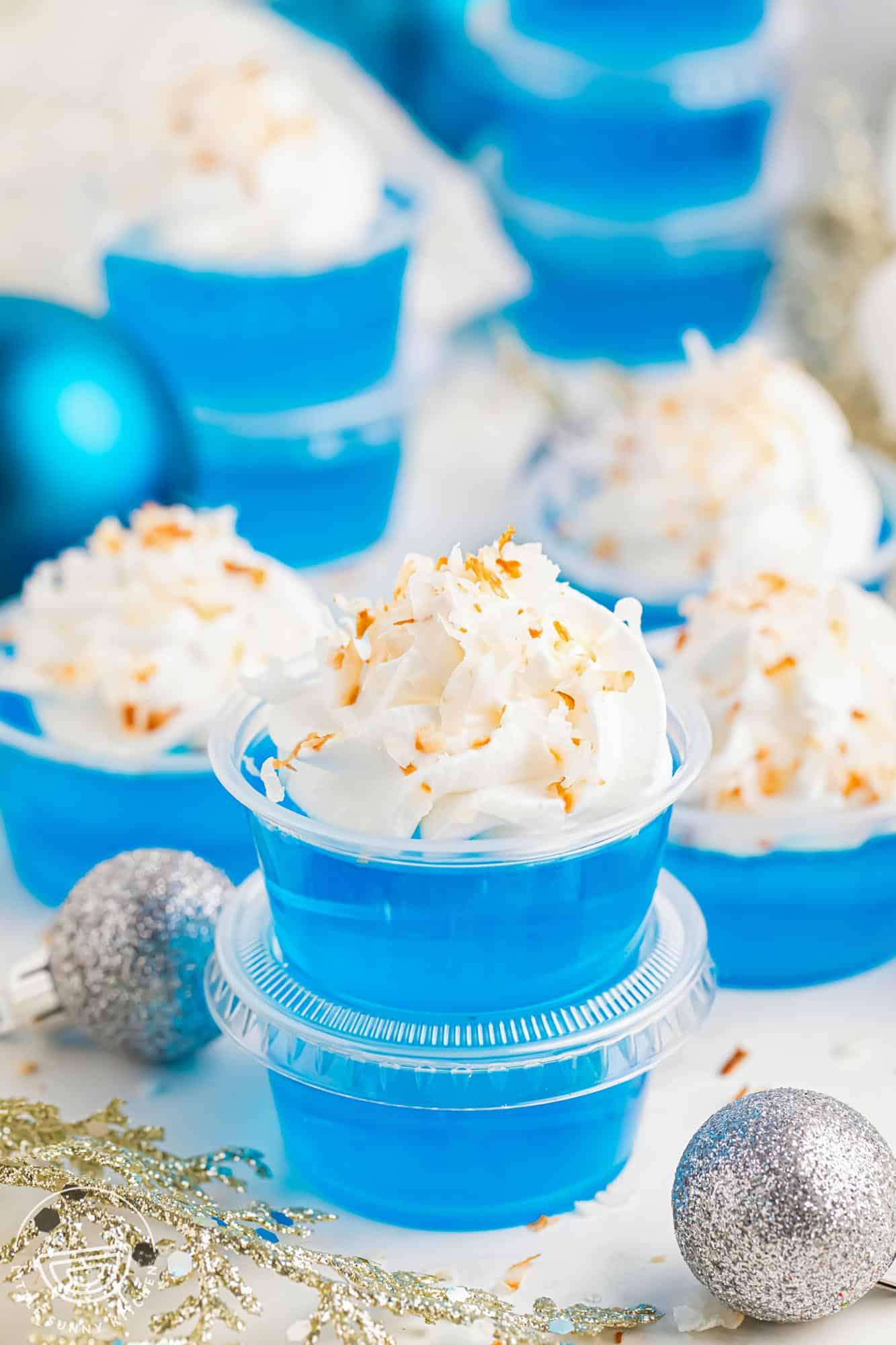 jack frost blue jello shots topped with coconut and whipped cream.