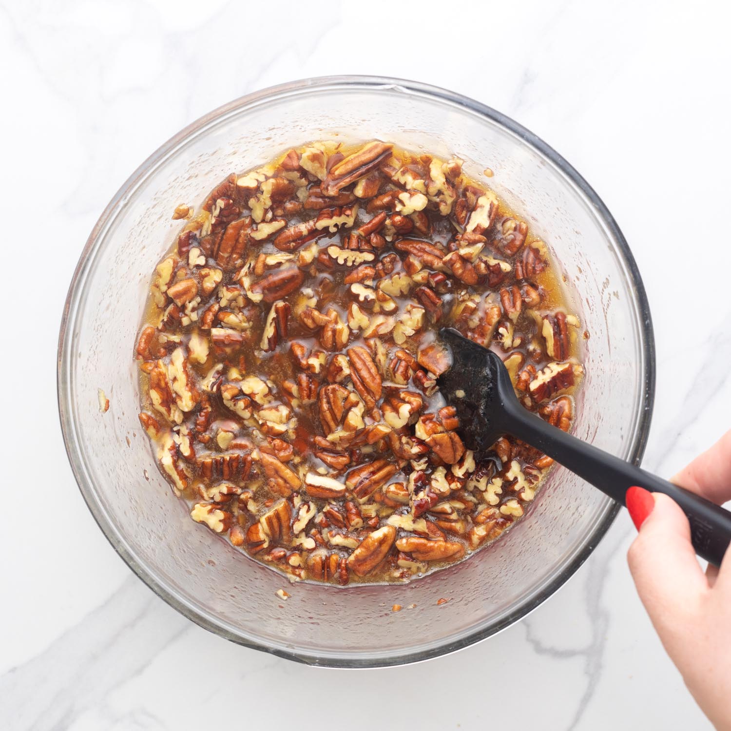 chopped pecans added to syrup mixture to make the topping for pecan pie bars.