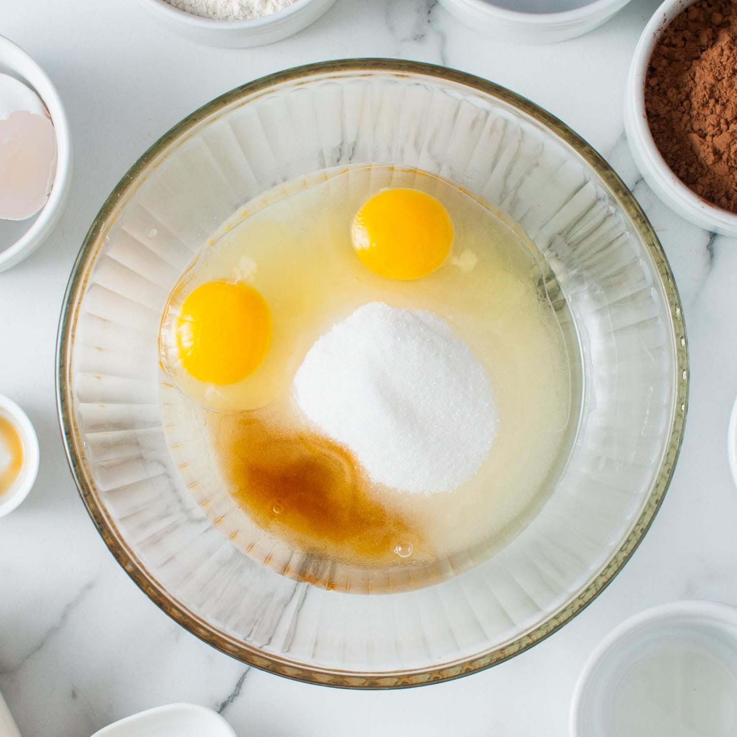 eggs, oil, sugar, and vanilla in a glass mixing bowl.