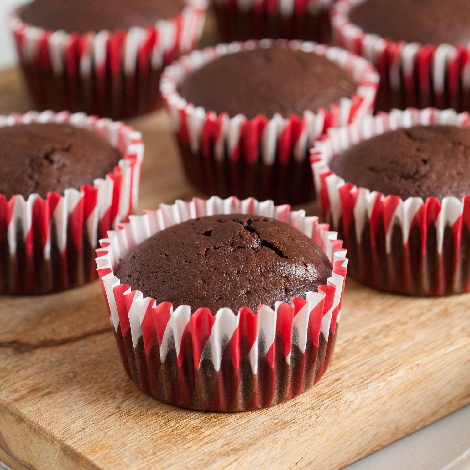 baked chocolate cupcakes in red and white striped papers.