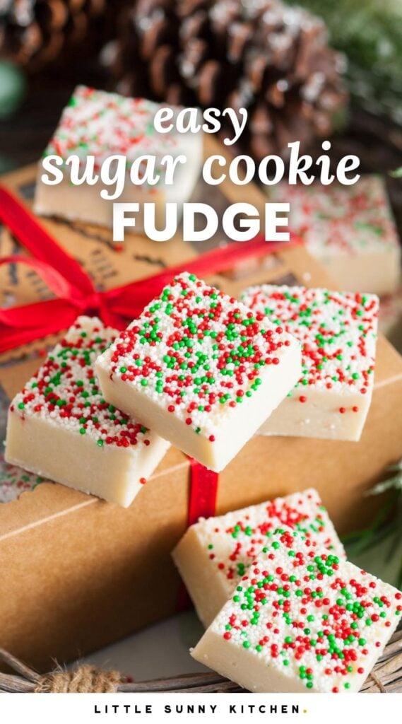 squares of holiday sugar cookie fudge next to a kraft paper gift box with a red ribbon. Text overlay says "easy sugar cookie fudge"