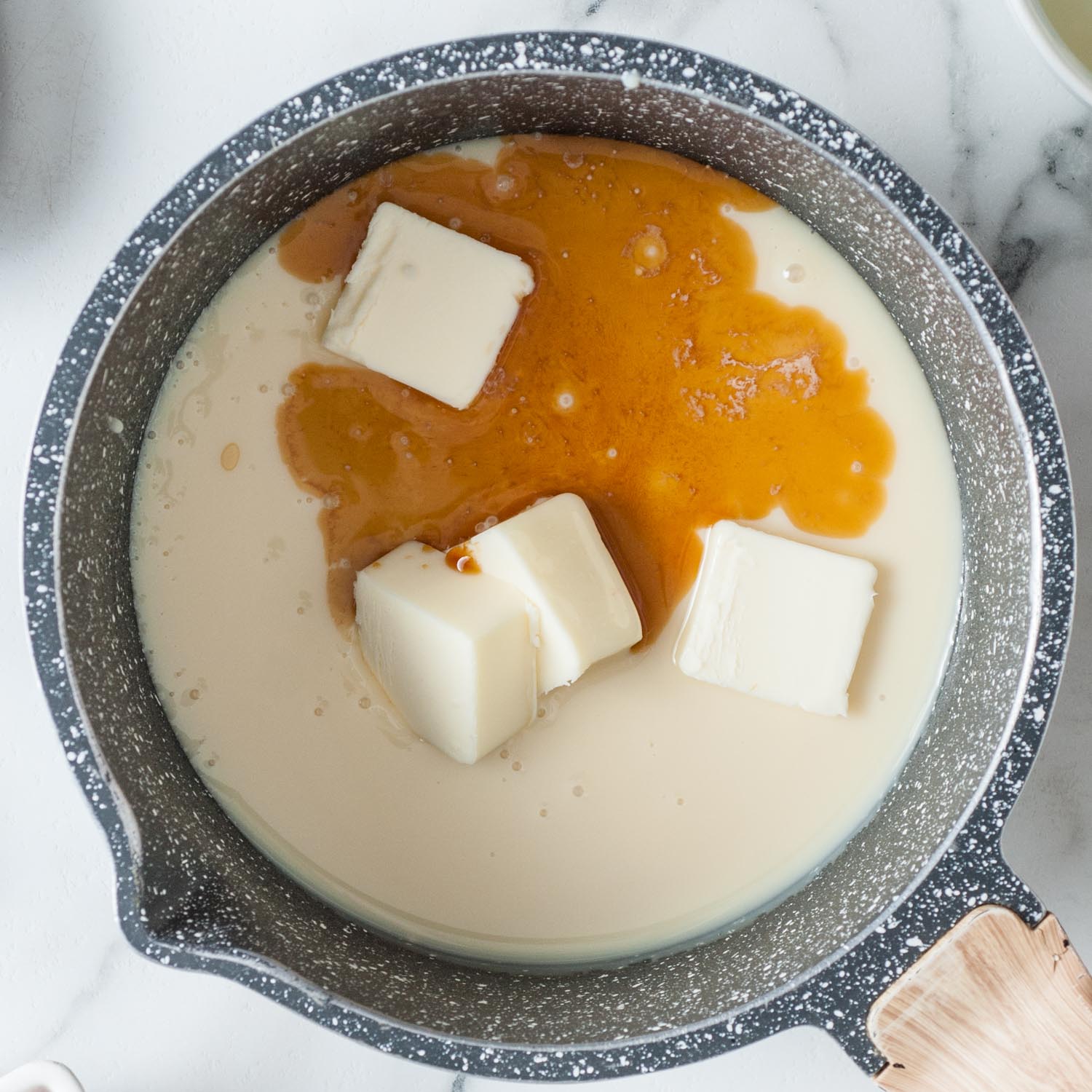 sweetened condensed milk, vanilla, and butter in a spotted enamel saucepan.