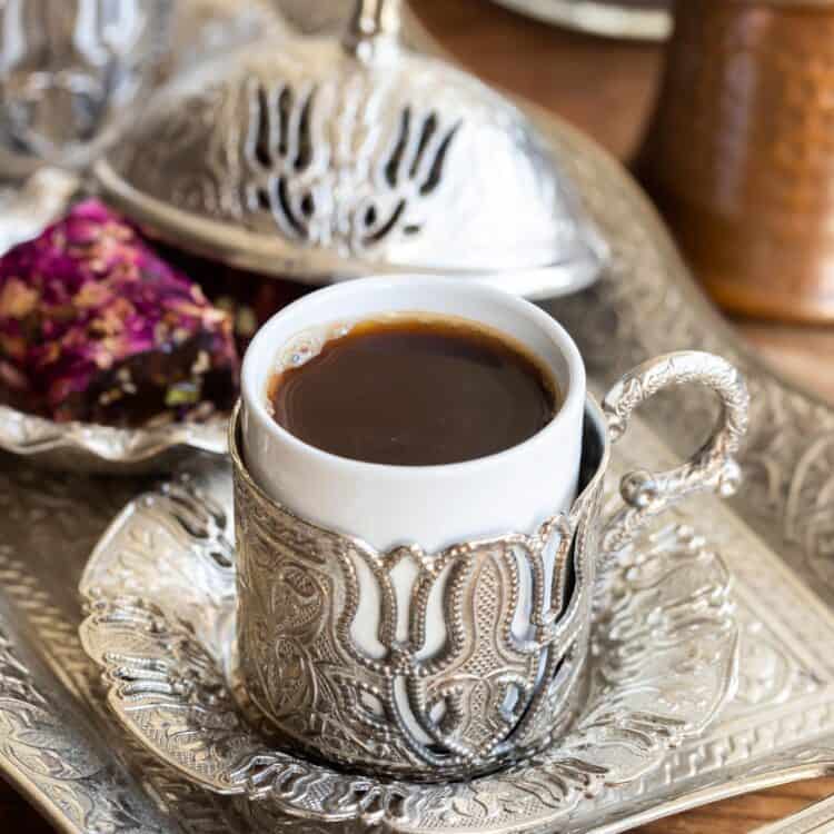 Turkish coffee served in a special cup with metal designs and tray