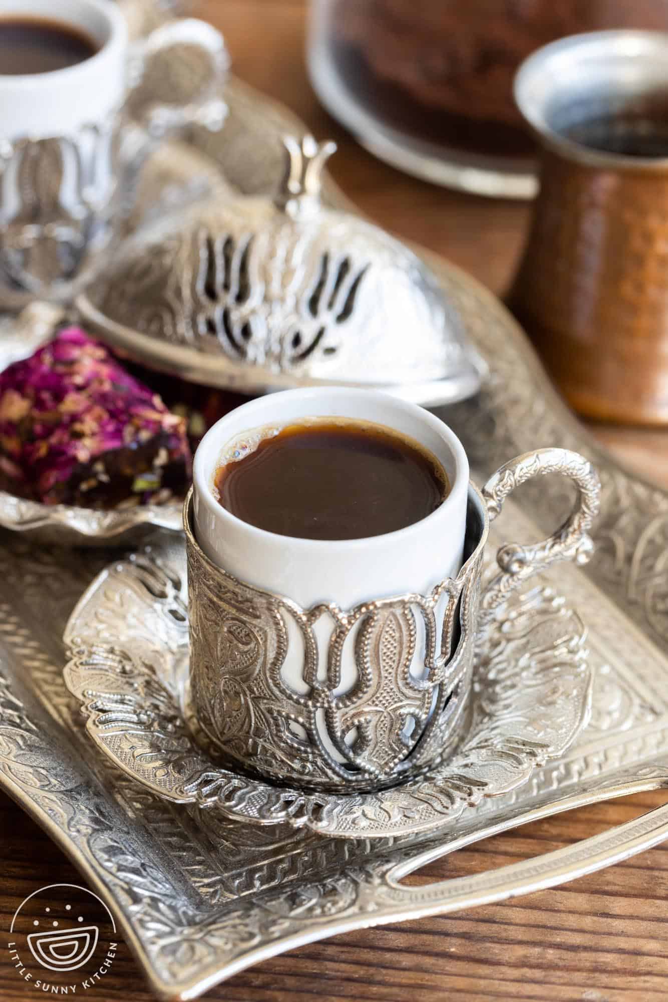 Turkish coffee served in a special demitasse cup with metal designs and tray