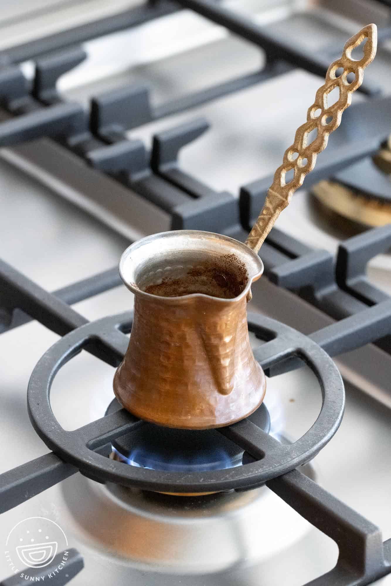 Turkish coffee in a turkish cezve on the stovetop