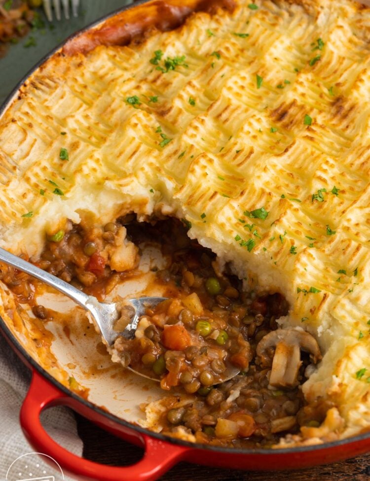 vegan shepherd's pie with textured criss cross mashed potato topping, served with a metal spoon.