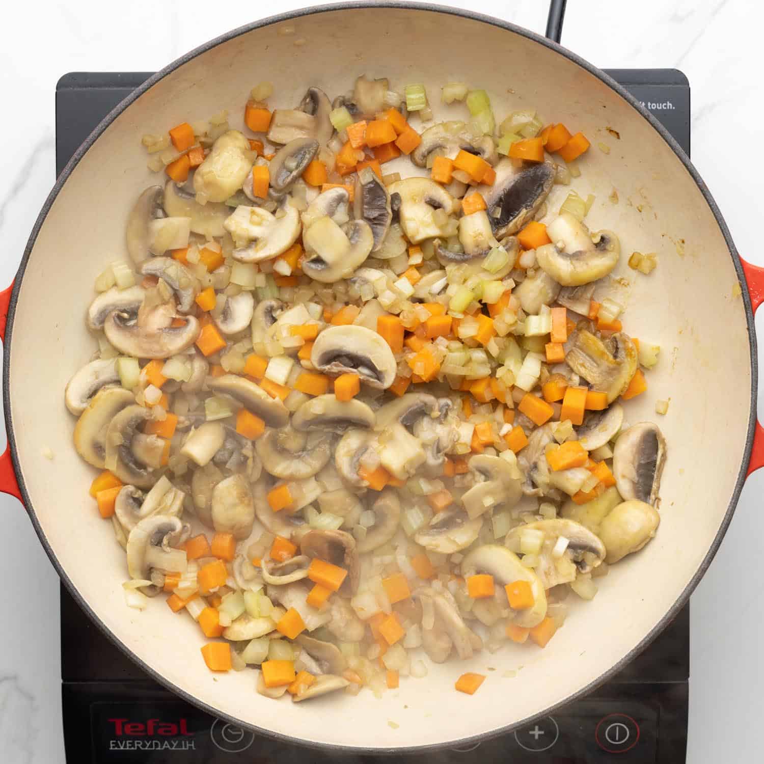 mushrooms and mirepoix sauteed in a large enameled skillet.