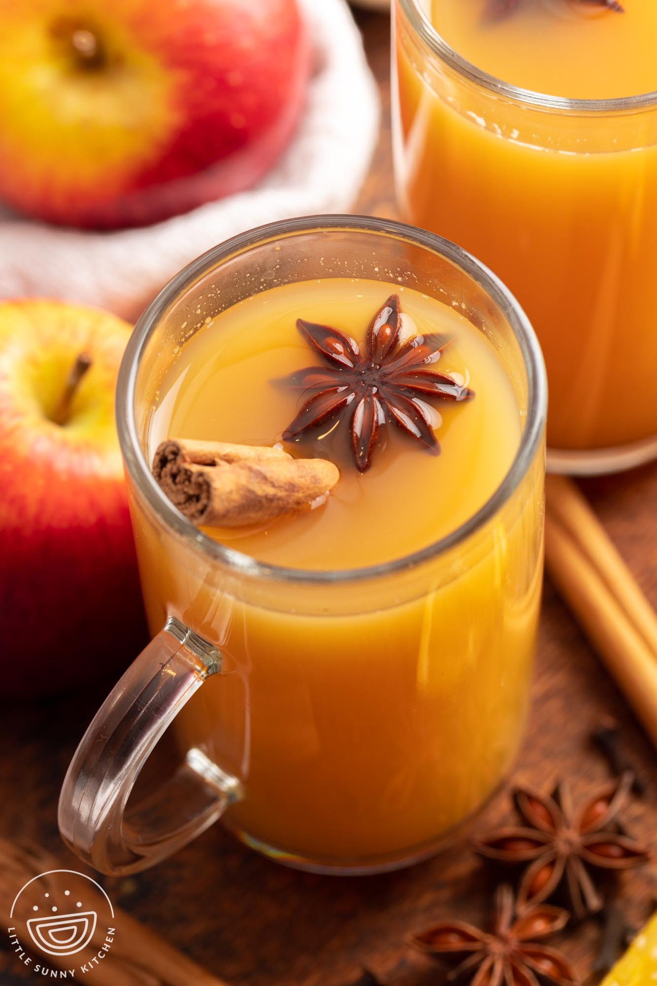 a mug of wassail topped with a whole anise flower pod and a whole cinnamon stick.