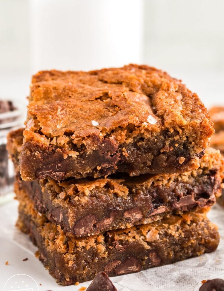 a stack of three chocolate chip brown butter blondies sprinkled with sea salt.