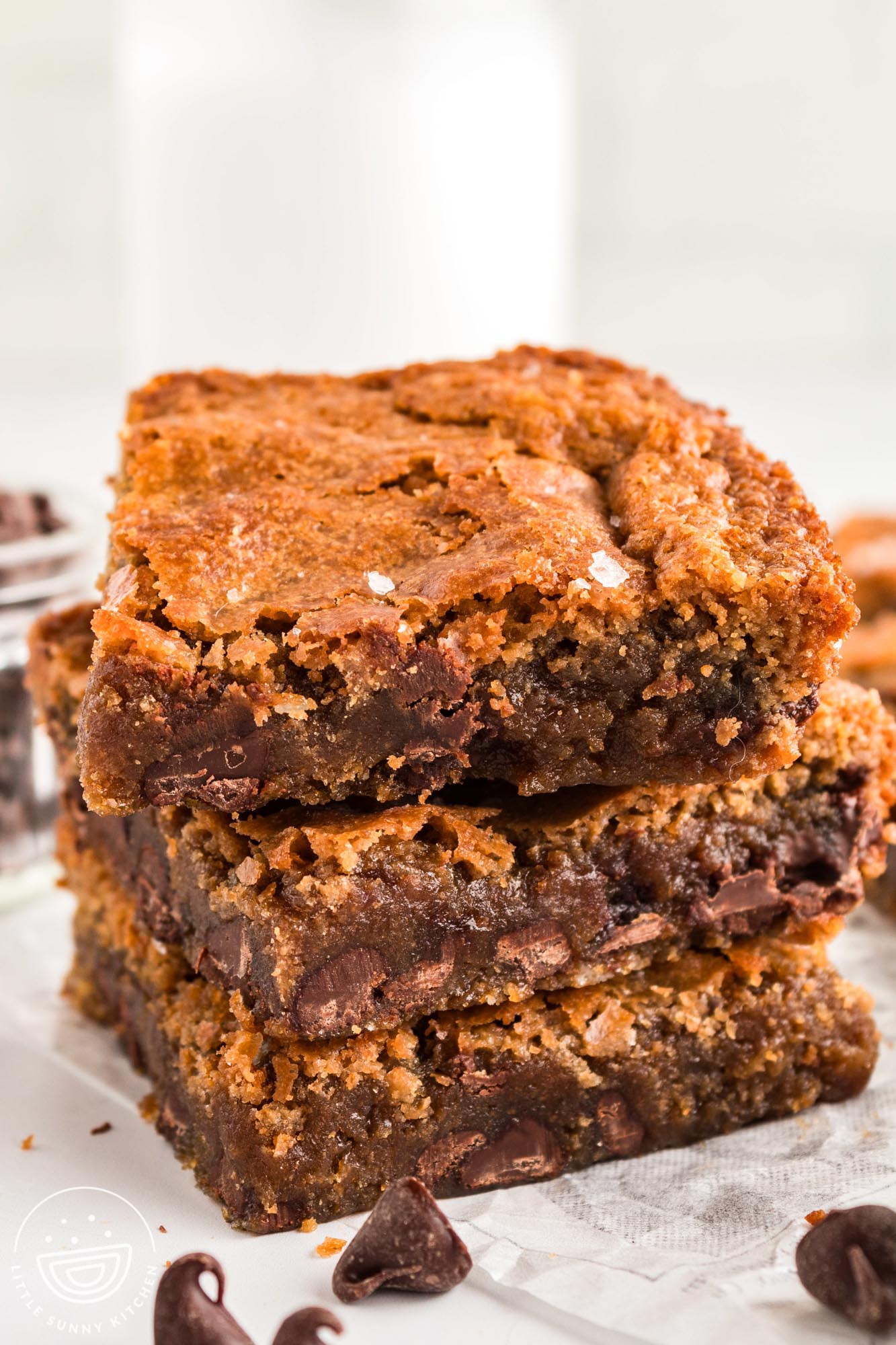 a stack of three chocolate chip brown butter blondies sprinkled with sea salt.