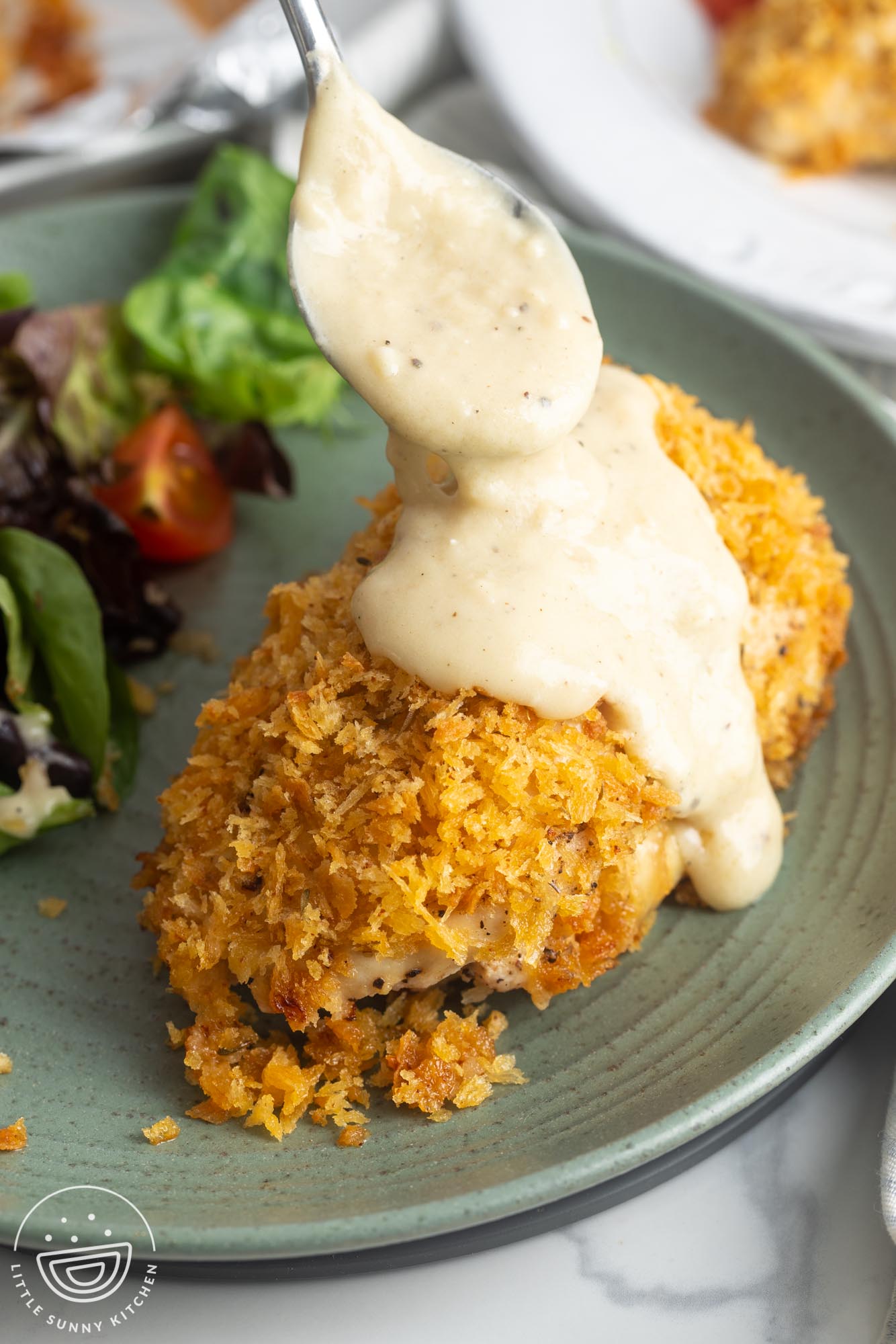 creamy sauce spooned over breaded baked chicken cordon bleu.