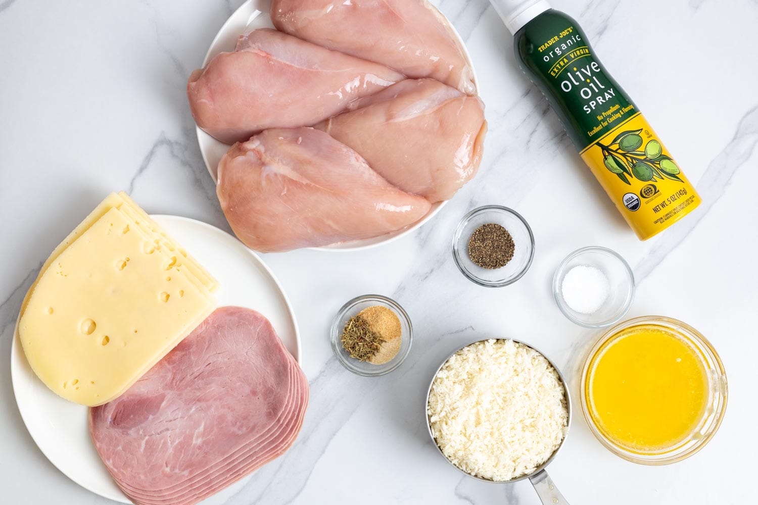 The ingredients needed to make homemade chicken cordon bleu, including chicken breasts, ham, swiss cheese, and panko.