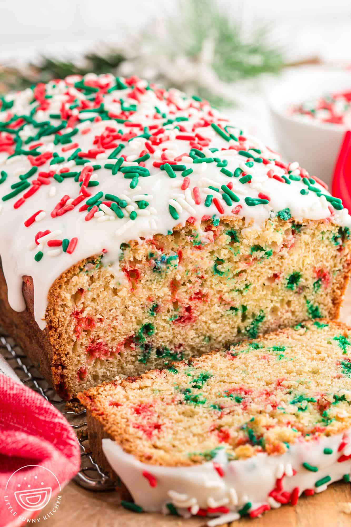 a loaf of Christmas Bread slided to show the red and green sprinkles inside.