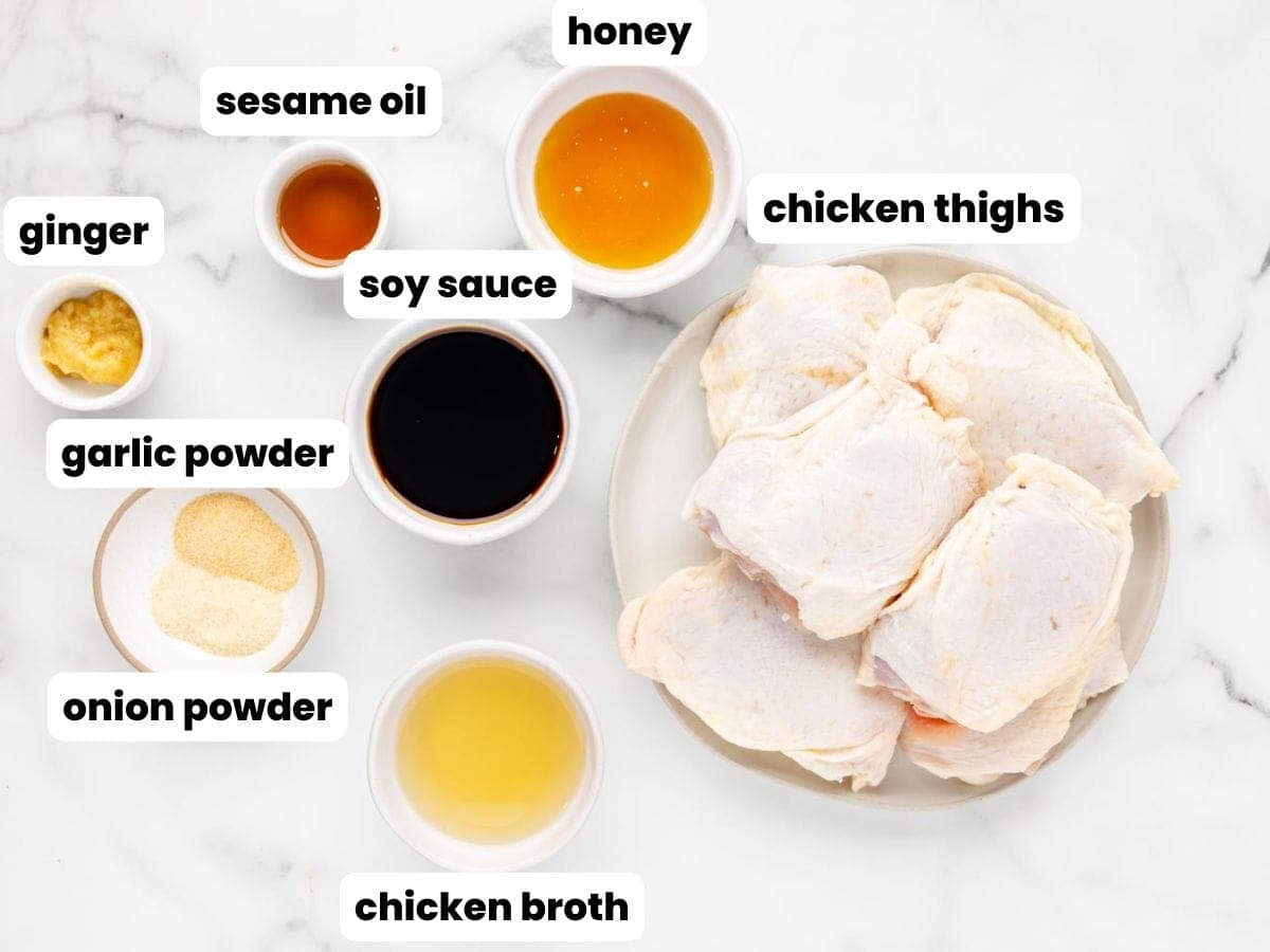 a plate of raw, bone in chicken thighs next to small bowls holding the ingredients for a honey soy marinade.