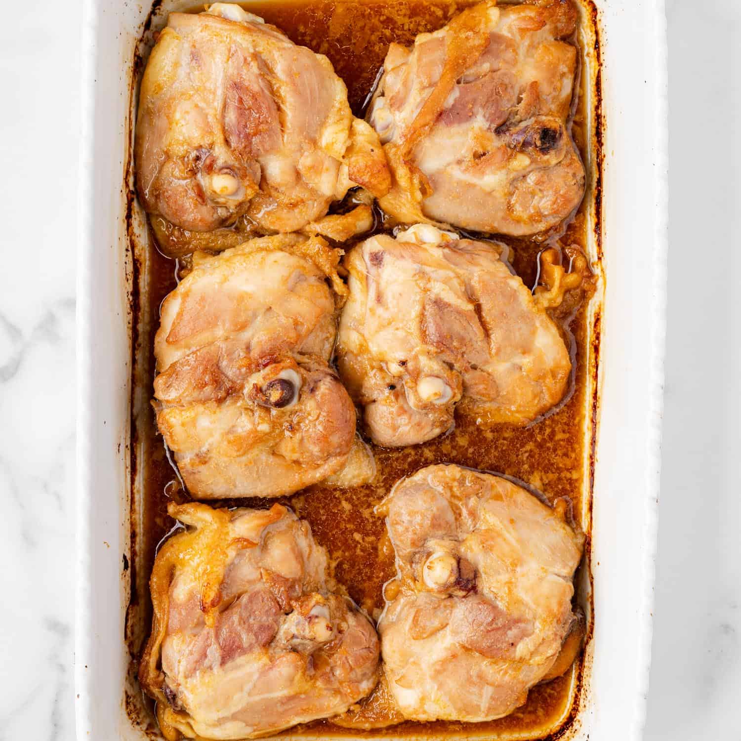 baked honey soy chicken thighs in a baking pan, skin side down.