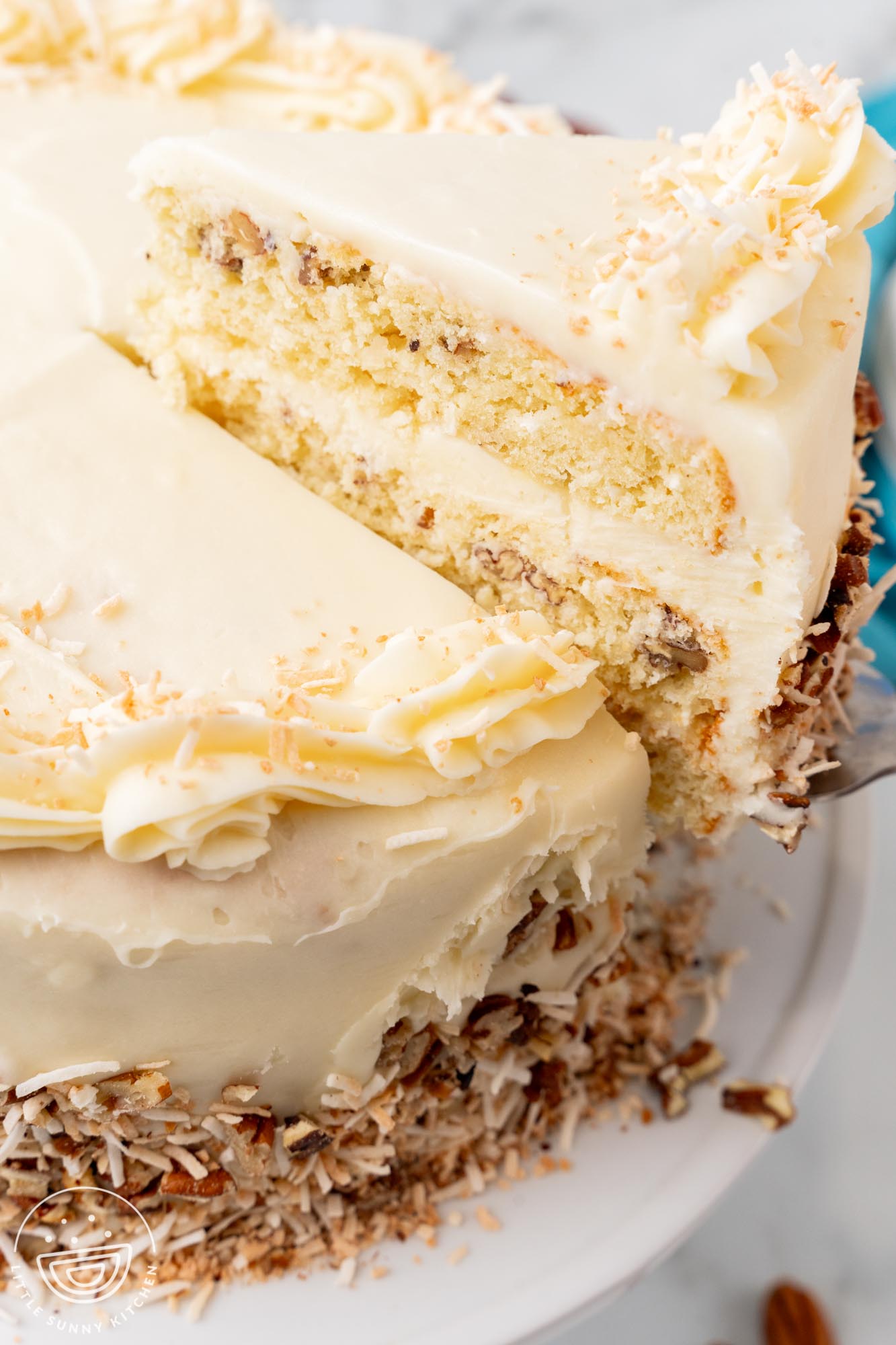 a slice of Italian cream cake, lifted from the platter.