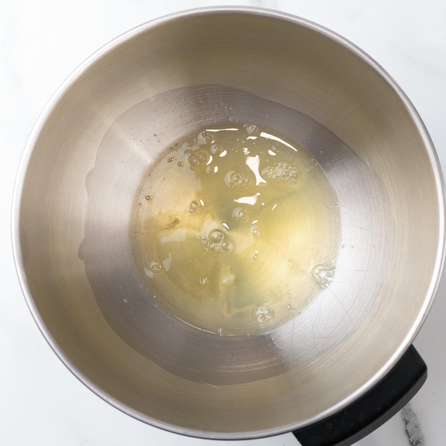 egg whites in a metal stand mixer bowl.